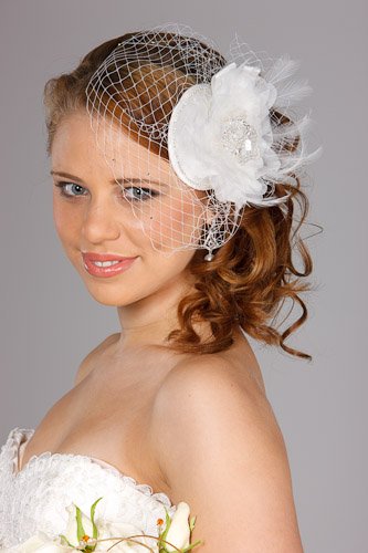Bride with tiara and rose bouquet on dark backdrop