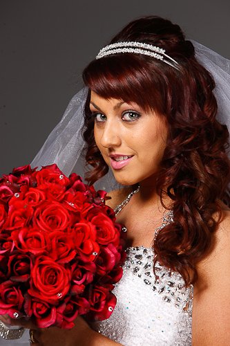 Bride seated with cathedral veil and rose bouquet